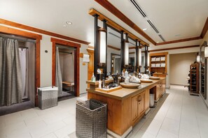 Un baño amplio con un tocador grande, varios espejos y un armario de madera.