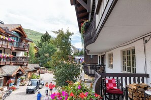 A traditional chalet with a balcony, wooden exterior, and flower boxes.