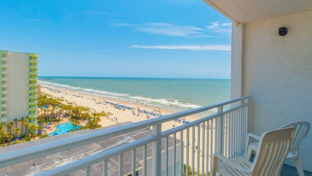 A balcony with a view of a beach and a pool area. - Sea Mist 51108 (Myrtle Beach)