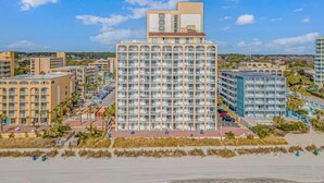 A high-rise hotel with multiple floors, a prominent rooftop structure, and a beachside location. - Sea Mist 51108 (Myrtle Beach)