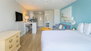 A hotel room with a bed, a desk, a chair, a sofa, and a TV. - Sea Mist 51108 (Myrtle Beach)