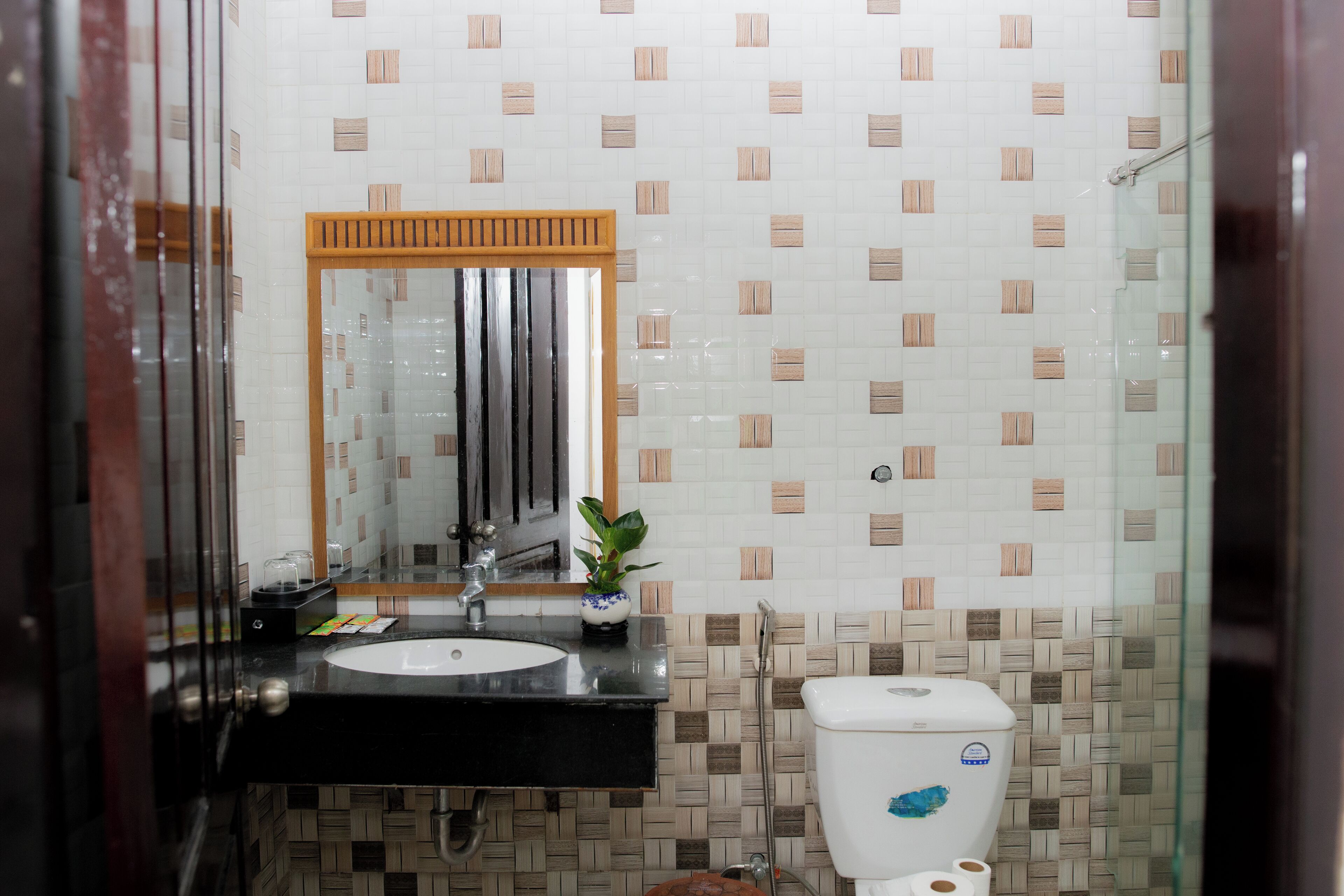 A bathroom with a black sink, a mirror, a toilet, and a shower area.