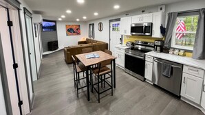 Una cucina moderna con zona pranzo, elettrodomestici integrati e vista sull'esterno.