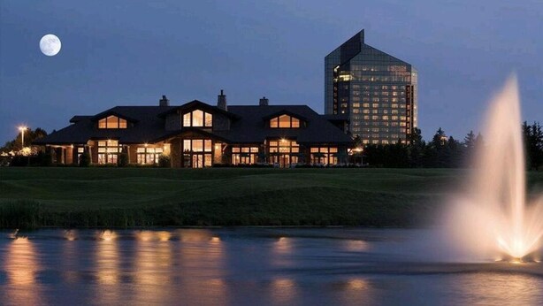 Ein großes Hotel mit mehreren Gebäuden, einer sichtbaren Fontäne und einem Mond am Himmel.