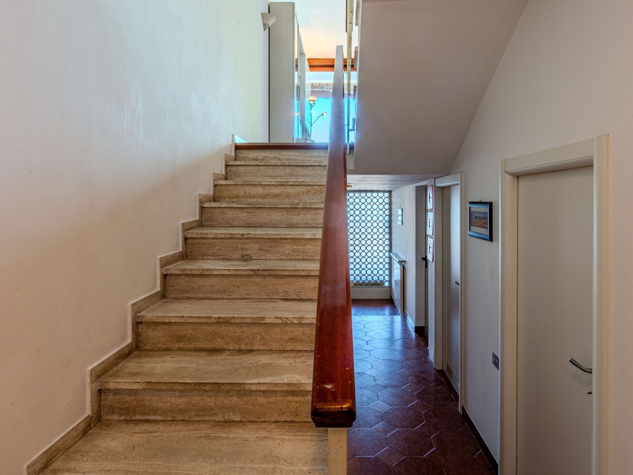 Un escalier avec une rampe en bois menant à un palier.