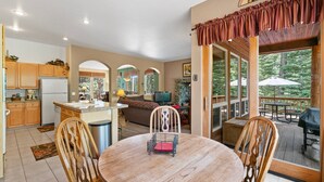 A spacious kitchen with wooden cabinets, a central island, and a dining area with a round table and chairs.