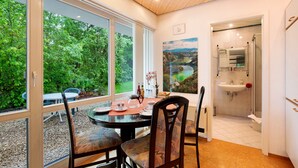 A dining area with a table, chairs, and a view of greenery outside. - Apartment 'Stumpp´s Appartement' with Private Terrace, Wi-Fi and Air Conditioning (Heroldstatt)