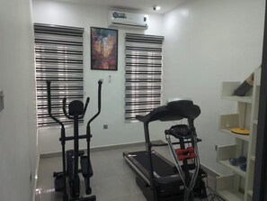 A room with a treadmill, an elliptical machine, and a wall-mounted air conditioner. - Best of Shimawa 2-Bed Luxury, 24/7 Electric/Wifi (Shimawa)