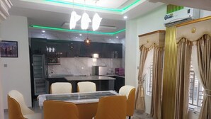 Un'area pranzo moderna con pavimento in marmo, un tavolo centrale e quattro sedie.