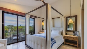 Una cama con dosel, una mesita de noche, una silla y vistas al exterior.