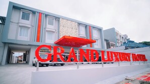 Ein modernes Gebäude mit einer auffälligen Schrifttafel, auf der "GRAND LUXURY HOTEL" steht.