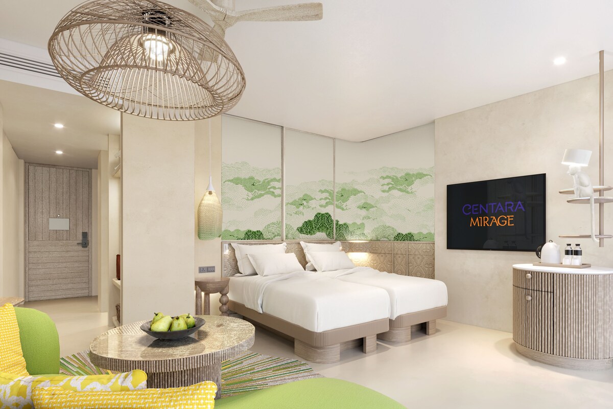 Camera d'albergo moderna con un letto grande, un tavolino rotondo, una TV e un mobile a parete.