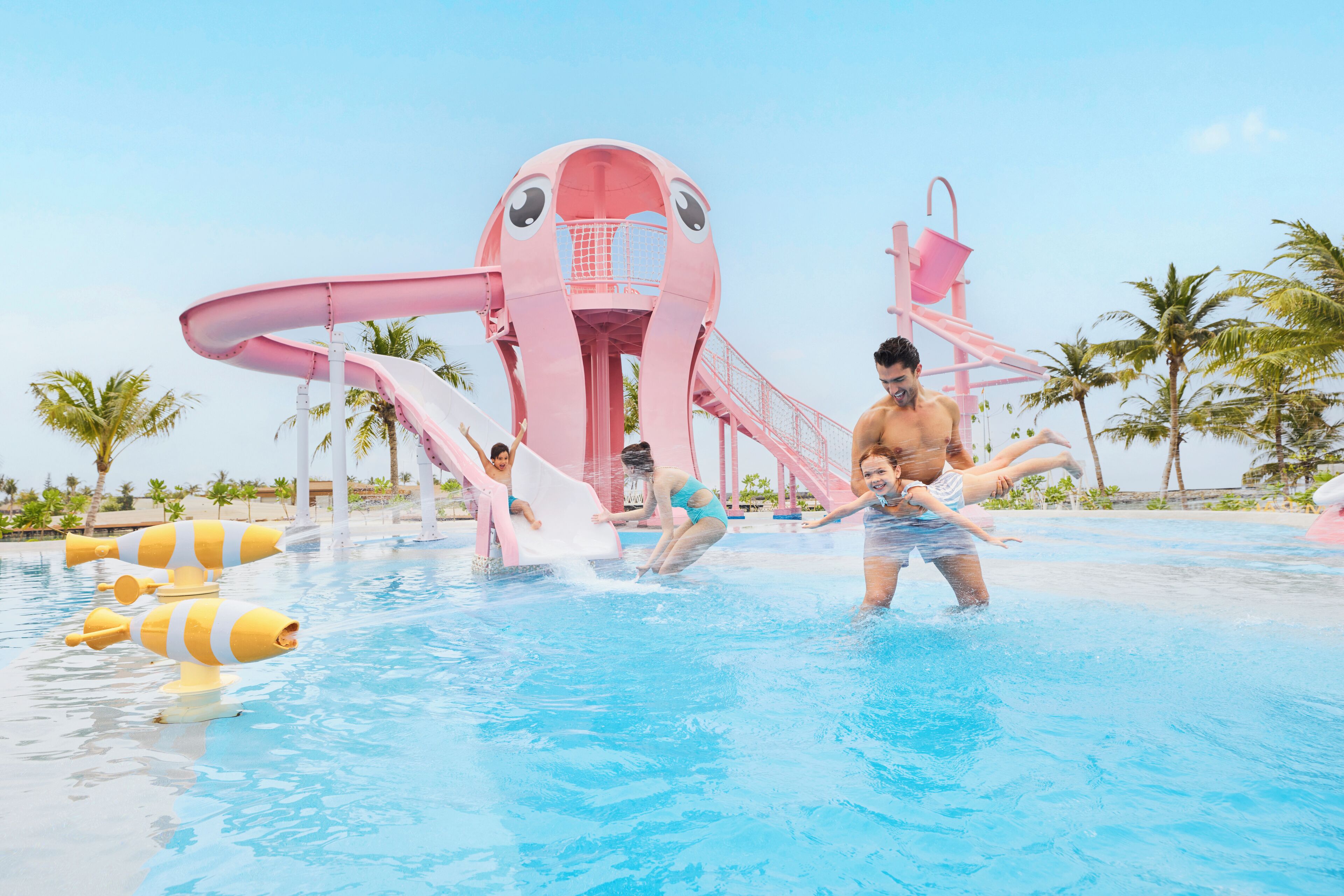 A water park with a large pink slide structure and a pool.
