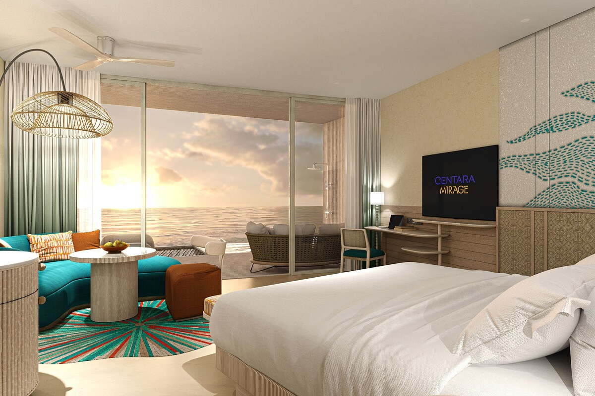 Una camera d'albergo moderna con un letto grande, una scrivania, una televisione e vista sul mare.