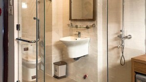 A modern bathroom with a glass-enclosed shower, a sink, and a toilet.