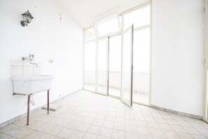 Bathroom features a large window, wall-mounted sink, and vintage-style lighting.