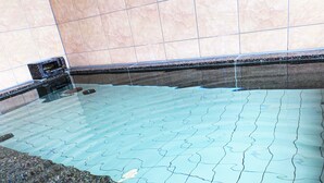 Una piscina con borde de azulejos y una fuente.