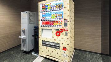 A vending machine with a Coca-Cola and Sprite selection, a water dispenser, and a small refrigerator labeled ICE.