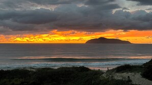 A coastal sunset with a distant island and overcast sky. - Hawks Nest - Magic Square Location (Hawks Nest)