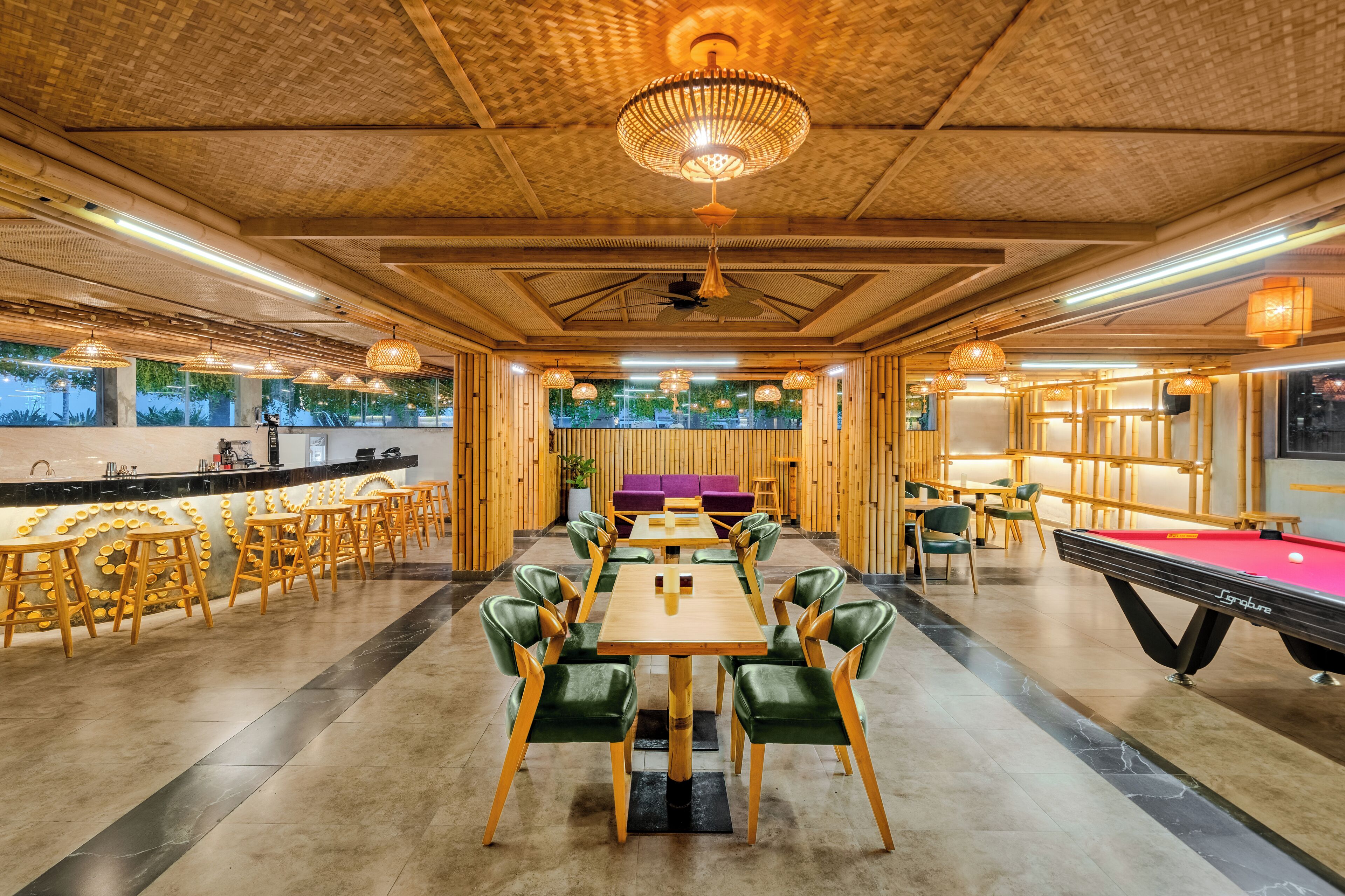 A spacious indoor area with a pool table, multiple seating arrangements, and a bar area.