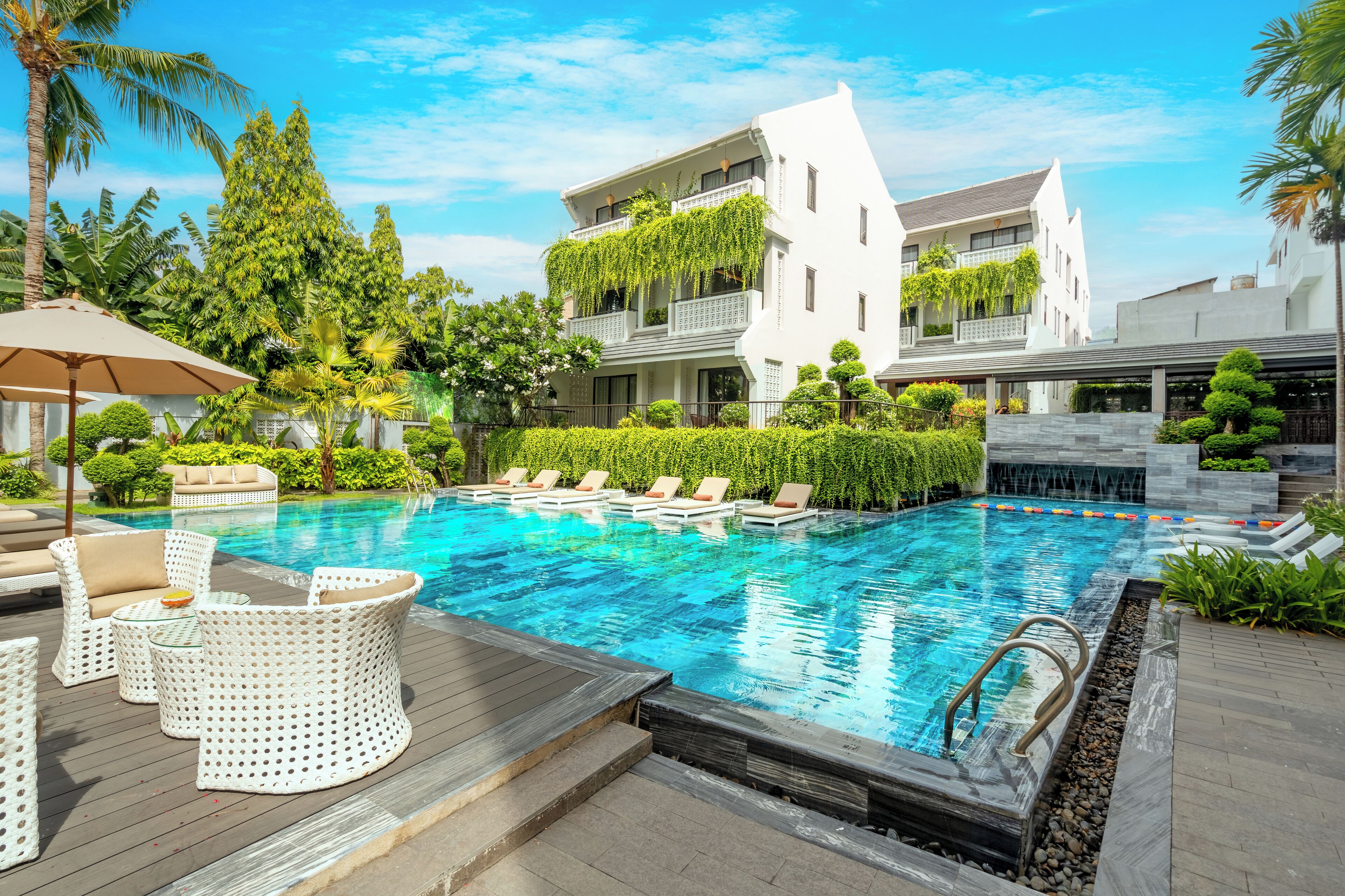 A swimming pool with lounge chairs and a wooden deck.