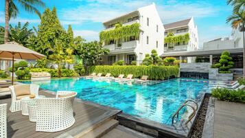 A swimming pool with lounge chairs and a wooden deck.