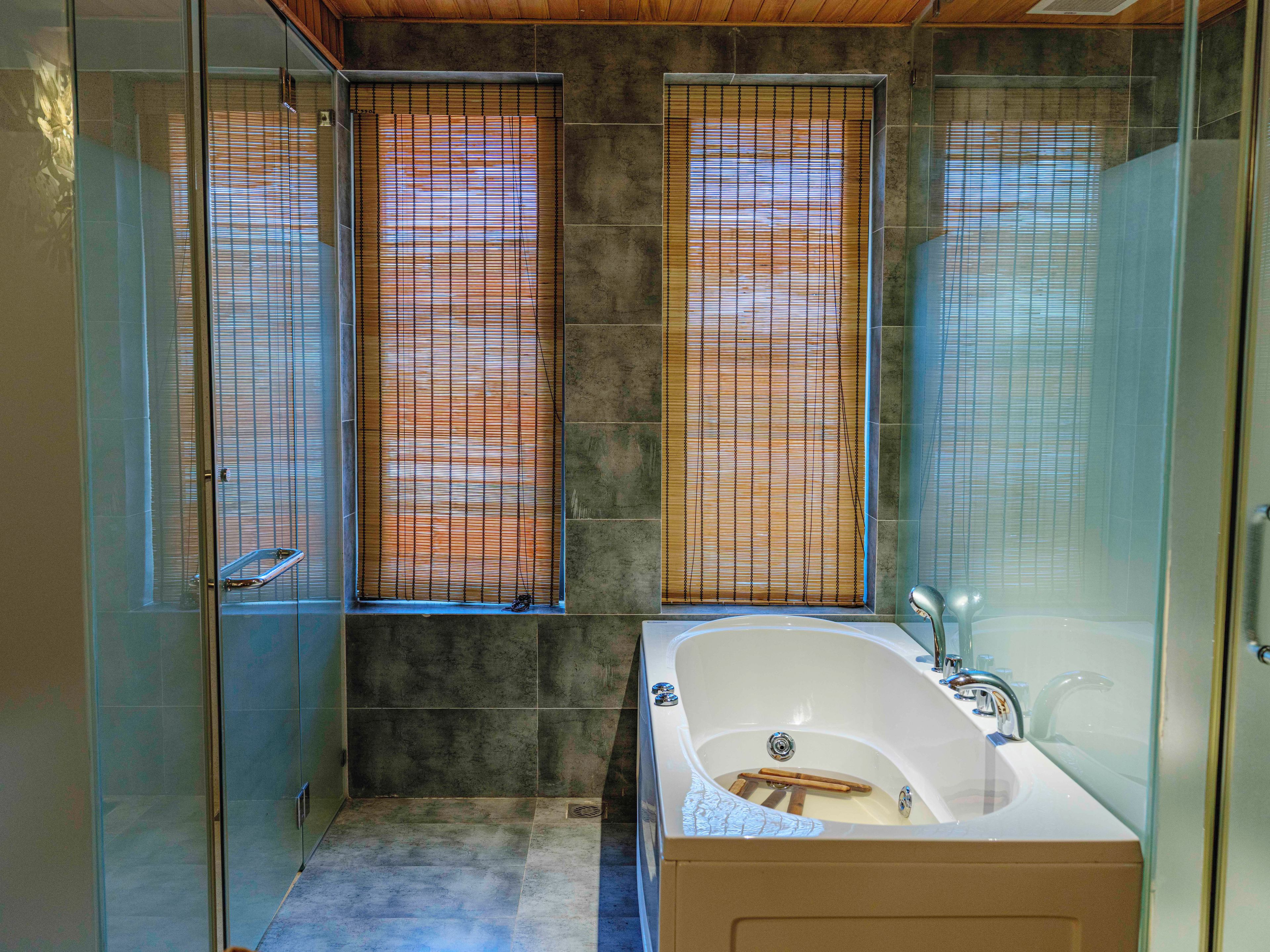 A bathroom with a bathtub, a shower, and a glass-enclosed shower area.