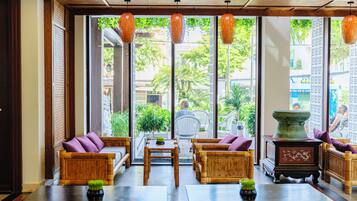A spacious lobby with a seating area, large windows, and a view of the outside.