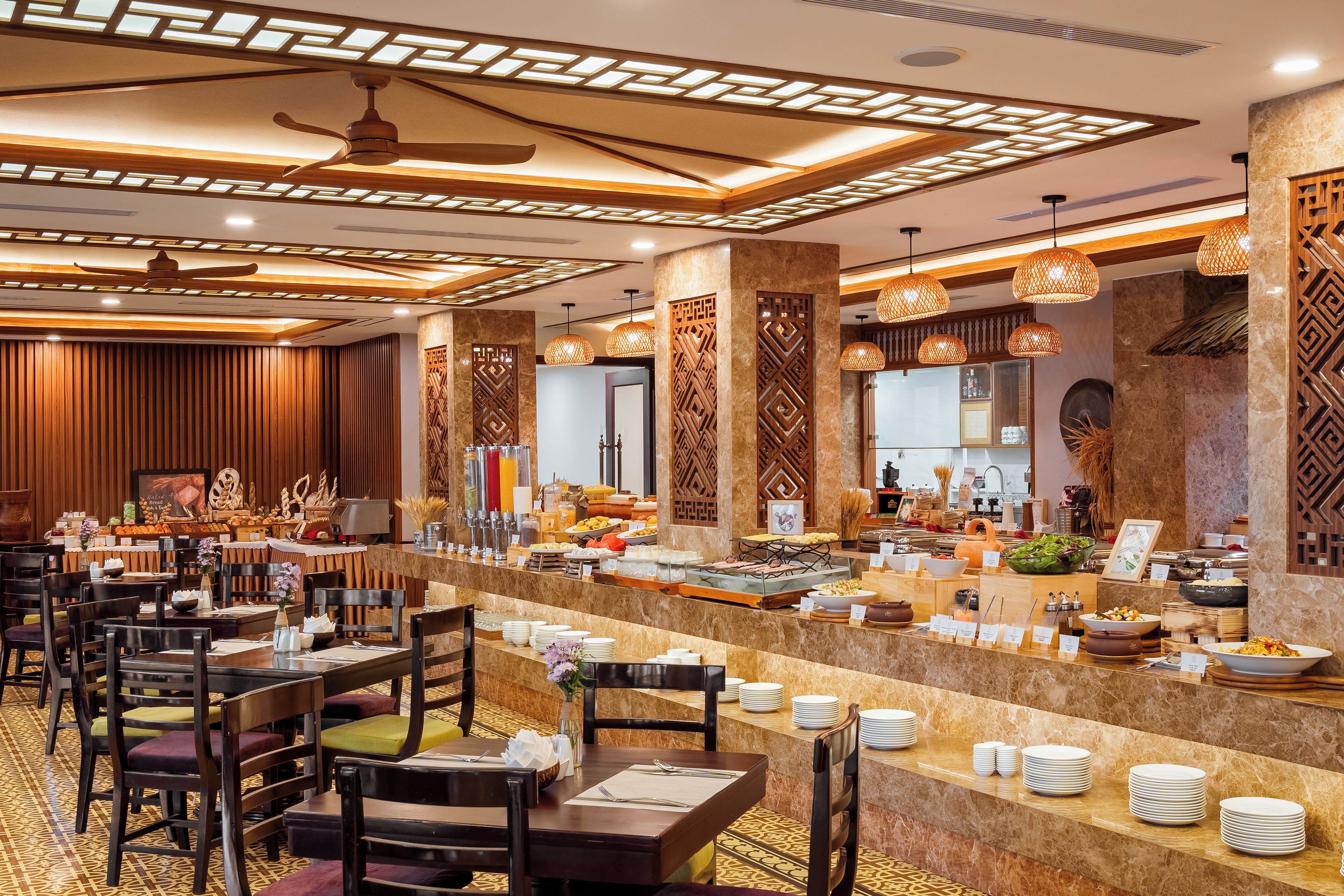 A hotel dining area with multiple tables, chairs, and a buffet counter.