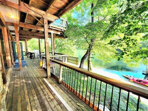 A wooden deck with a railing overlooking a river. - White River Lodge #1 (Lakeview)