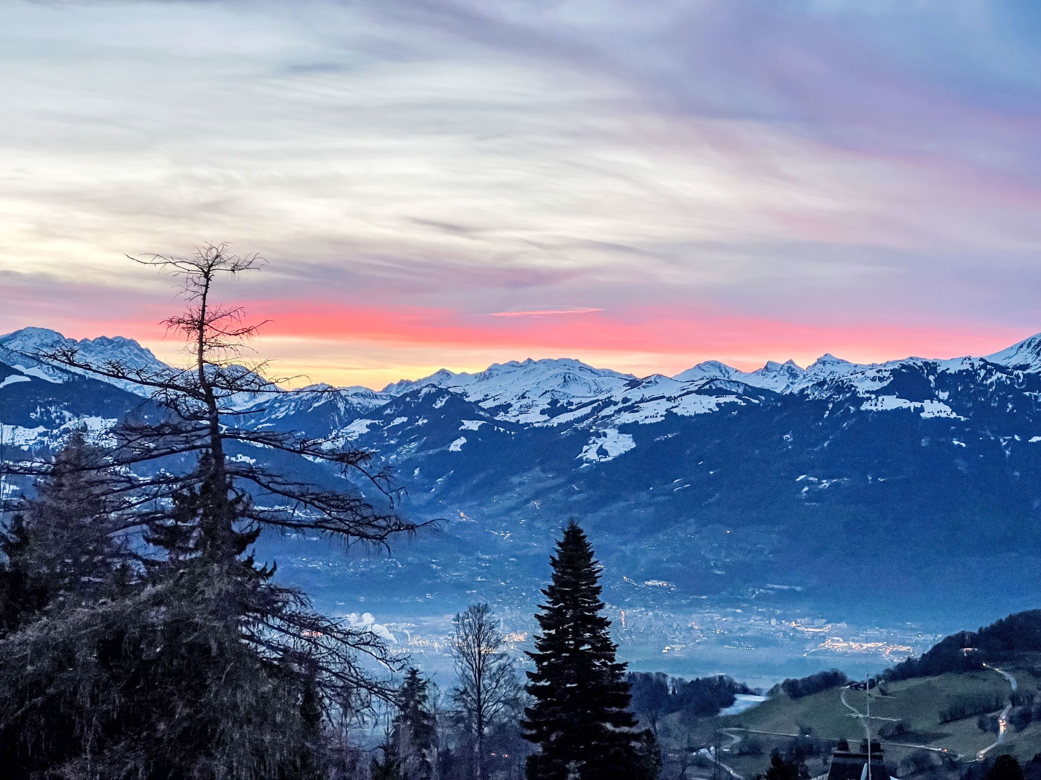 A mountainous landscape with snow-capped peaks and a clear sky.