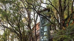 A modern building with a stone facade, a car parked in front, and a sign for 'The Pine Retreat'. - The Pine Retreat - Mall Road Dalhousie (Dalhousie)
