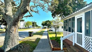 A residential street with a large tree, a sidewalk, and a house with a porch. - 3 Bdrm in Historic Downtown (Morehead City)