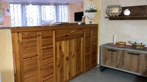 Una cocina con armarios de madera, una encimera y una pequeña mesita con cestas.