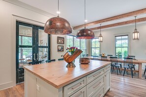 A spacious kitchen with a large island, wooden countertops, and copper pendant lighting. - Idyllic Belmont Home < 1 Mi to Historic District! (Belmont)