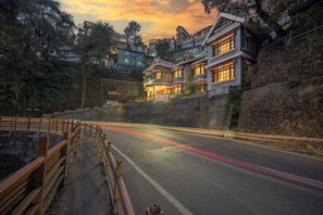 A hotel with a stone facade, multiple balconies, and a sign indicating it is a hotel. - Wingait Inn - Hotel Near The Mall Road (Shimla)