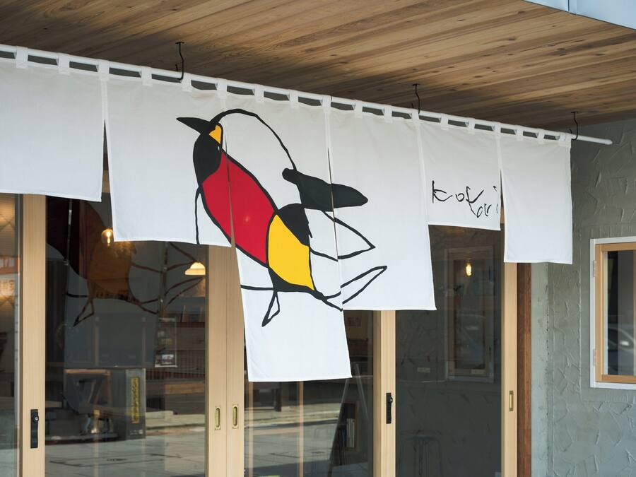 Een gebouwhal met een grote muurschildering van een vogel op een witte banner.
