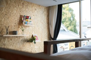 Um quarto com parede de madeira, uma janela com cortinas e uma cama.