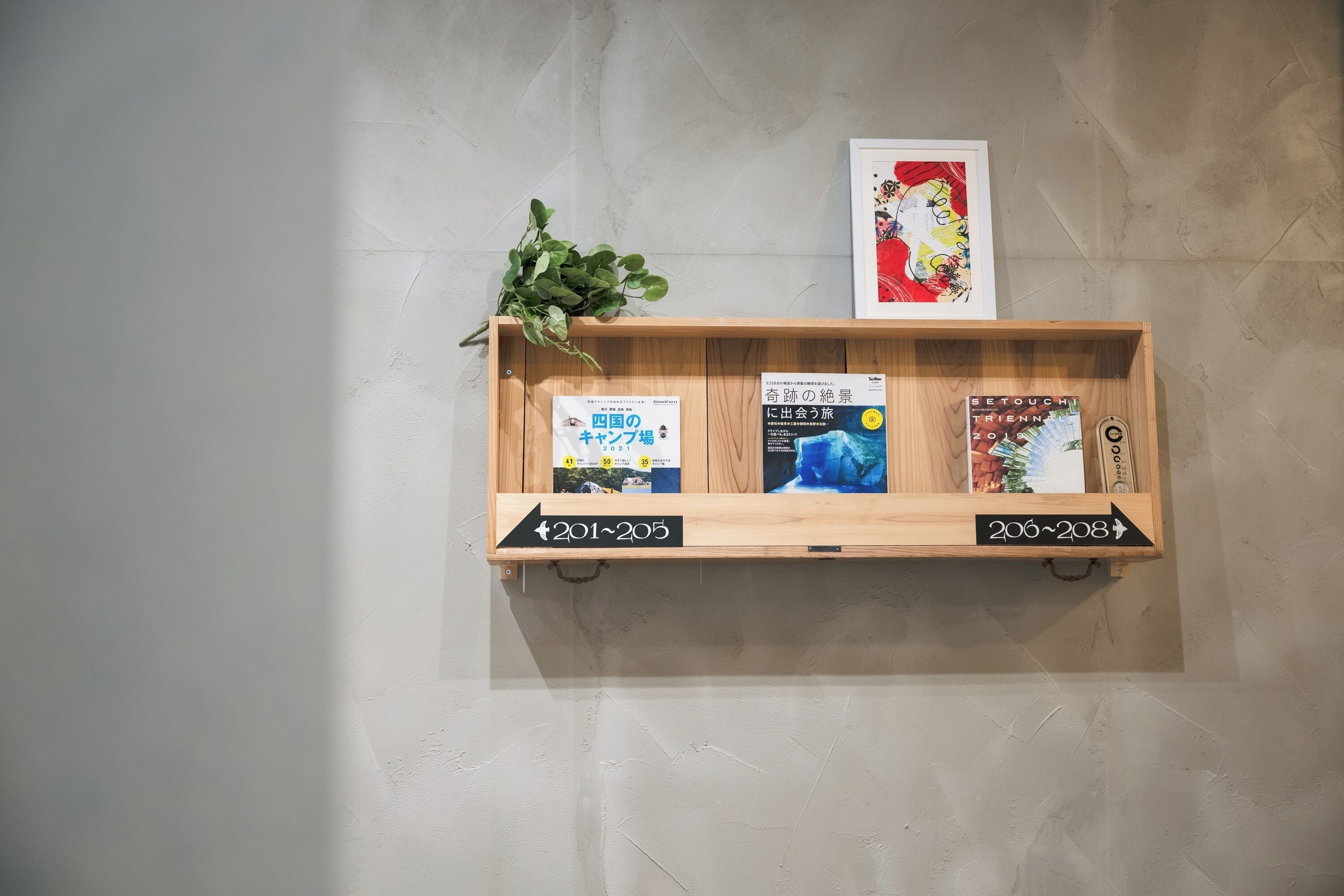 Una repisa de madera con libros y un marco con una fotografía en la pared.