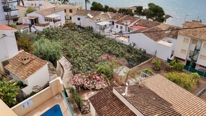 Zona residencial con casas escalonadas, piscina y vista al mar.