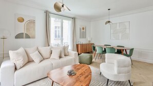 En moderne stue med sofa, sofabord og spiseområde med stole og bord.