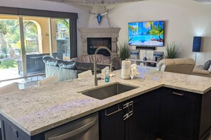 A modern kitchen with a granite countertop, a built-in sink, and a black cabinetry.