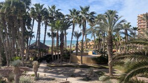 Un resort con palmeras, piscina y vista al océano.
