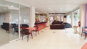 A hotel lobby with a reception desk, seating area, and a fire extinguisher. - Humbertos Hotel (Davao)