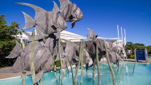 A pool with a sculpture of fish. - Adorable Beach Cottage,1 Block from Beach + Kure Beach Pier, Dog Friendly with Fence (Kure Beach)