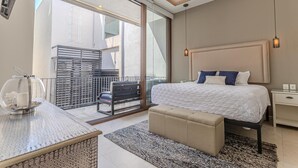 A modern bedroom with a large bed, a nightstand, a bench, and a view of the outside. - Penthouse in Romantic Zone! Pacifica 604 2BD Penthouse for rent in Old Town, Pue (Puerto Vallarta)