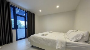 Un dormitorio con cama, ventana y puerta.