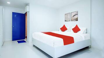 Camera da letto moderna con un letto bianco, cuscini rossi e una porta blu.