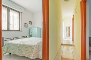 A bedroom with a bed, a dresser, and a window with curtains. - Villa Mattalia 500m From Sea (Manduria)
