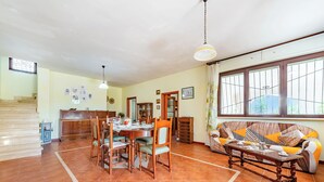 A spacious living area with a dining table, chairs, a sofa, and a staircase. - Villa Mattalia 500m From Sea (Manduria)